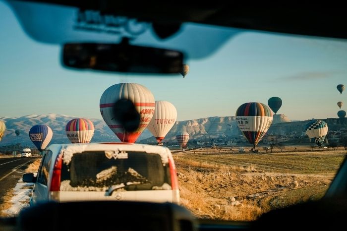 Stunning panoramic view of Cappadocia with hot air balloons floating over the fairy chimneys at sunrise